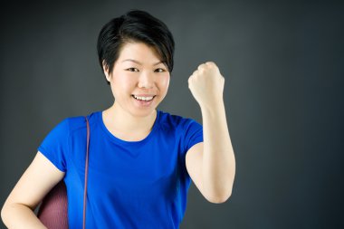 Kadın yumruğunu gösteriyor.