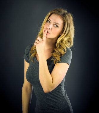 dudaklarında parmak ile sessizlik isteyen kadın