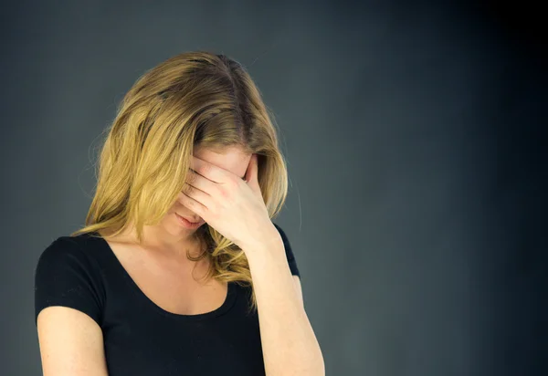 Mujer avergonzada escondiéndose cara en mano — Foto de Stock