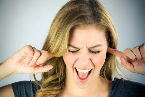 Woman plugging ears with fingers — Stock Photo, Image