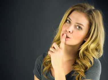 dudaklarında parmak ile sessizlik isteyen kadın