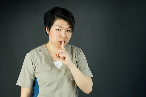 Donna che chiede silenzio con un dito sulle labbra — Foto Stock