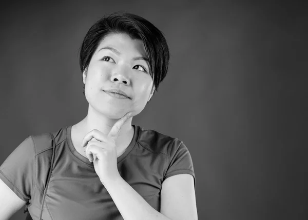 Frau denkt mit dem Finger am Kinn — Stockfoto