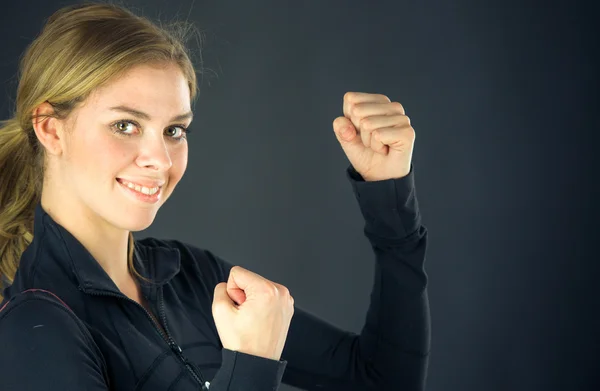 Vrouw vieren van succes met vuisten omhoog — Stockfoto