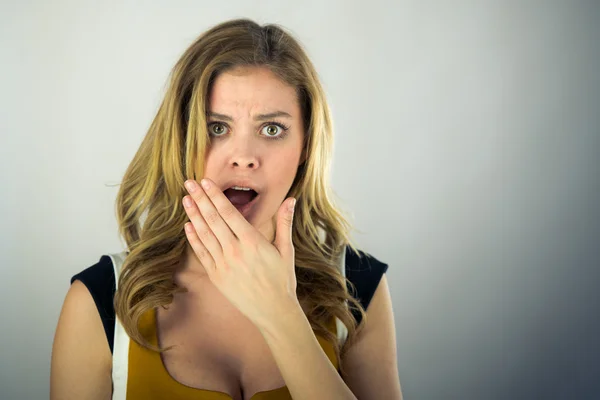 Förvånad kvinna som täcker munnen för hand — Stockfoto