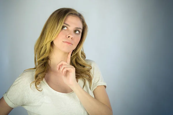 Woman thinking with finger on chin — Stock Photo, Image