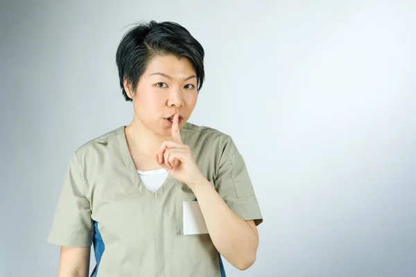 Kvinna ber om tystnad med finger på läppar — Stockfoto