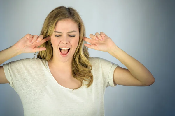 Woman plugging ears with fingers — Stock Photo, Image