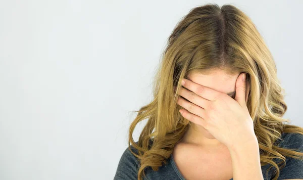 Woman ashamed hiding face in hand — Stock Photo, Image