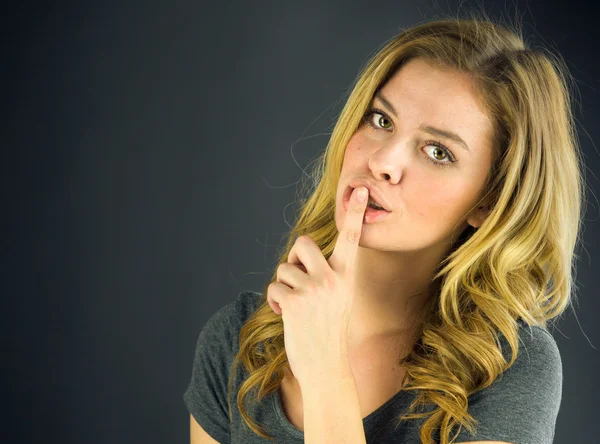 Kvinna ber om tystnad med finger på läppar — Stockfoto