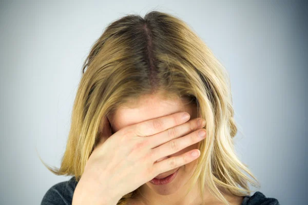 Donna si vergogna di nascondere la faccia in mano — Foto Stock