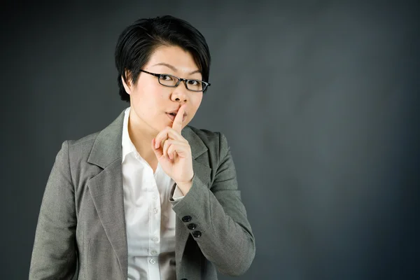Donna che chiede silenzio con un dito sulle labbra — Foto Stock