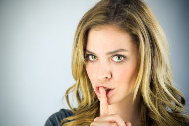 dudaklarında parmak ile sessizlik isteyen kadın