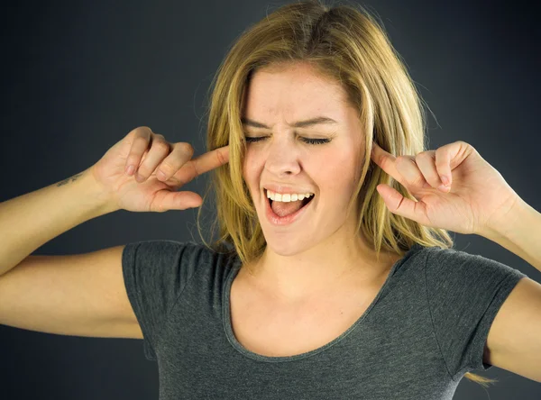Woman plugging ears with fingers — Stock Photo, Image