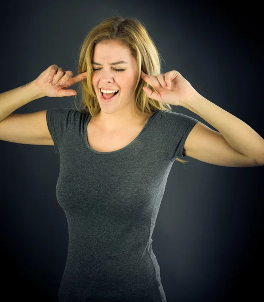Vrouw inpluggen oren met vingers — Stockfoto