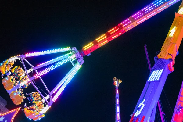 View of illuminated roller coaster at amusement park
