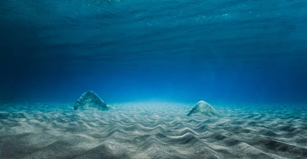 View of underwater stones with rippled sand