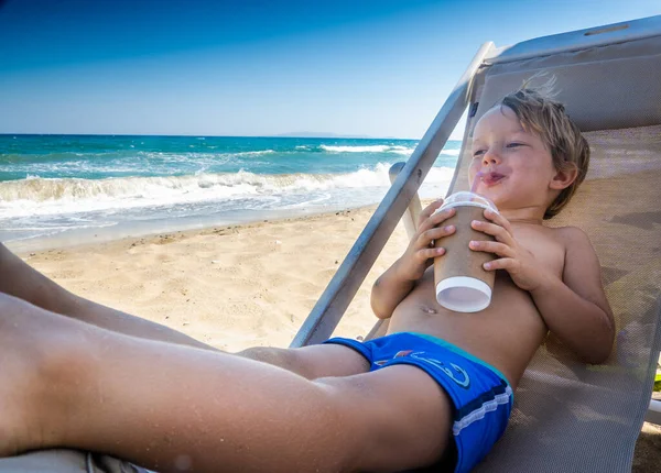 Chłopiec Pijący Kawę Podczas Kąpieli Słonecznej Plaży — Zdjęcie stockowe