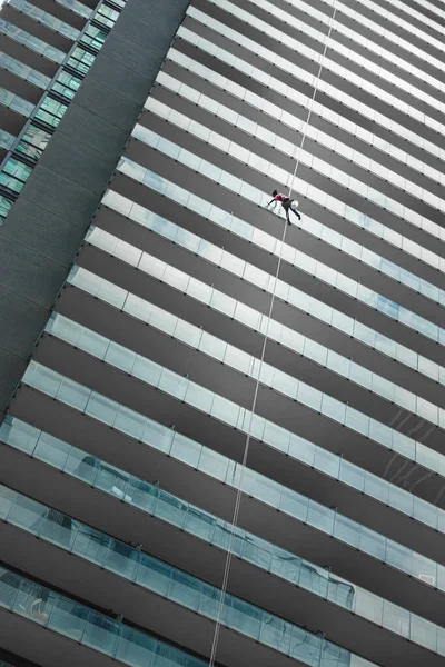 Arbeiter Klettert Mit Eimer Und Sicherungsseil Spiegelwand Eines Modernen Gebäudes — Stockfoto