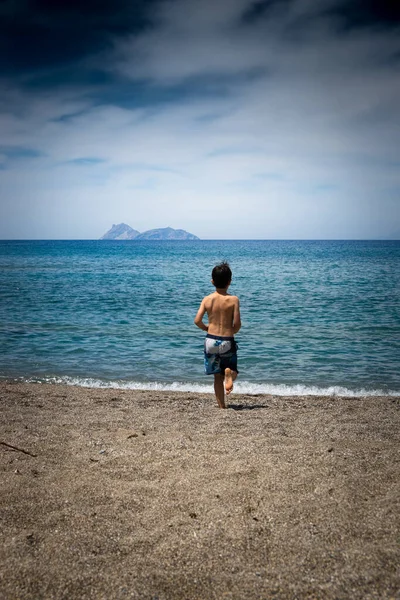 海に向かって走る少年の後ろ姿 — ストック写真