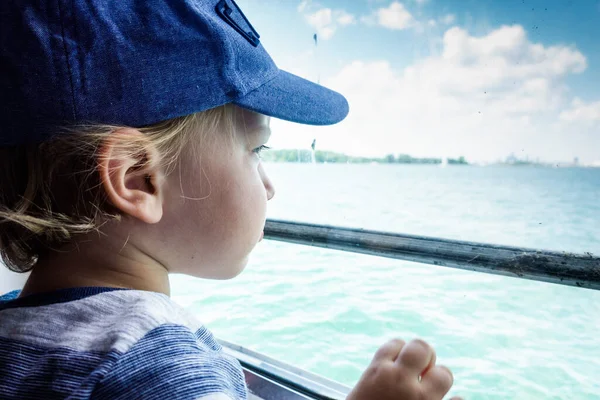 男孩看着窗外的渡船 — 图库照片