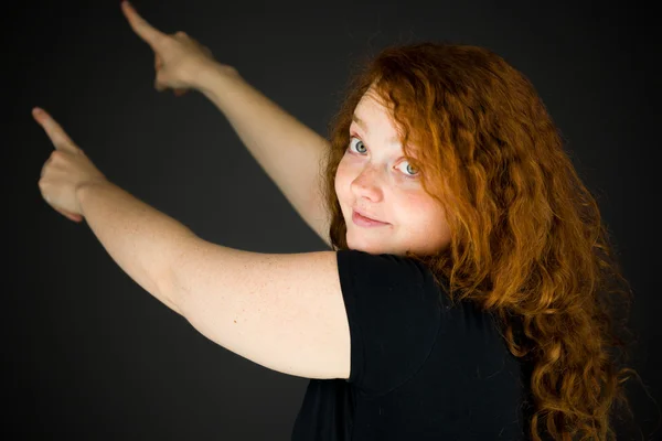 Model looking at camera and pointing — Stock Photo, Image