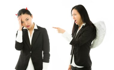 Angel side of a young Asian businesswoman showing finger, screaming and scolding to devil side isolated on white background