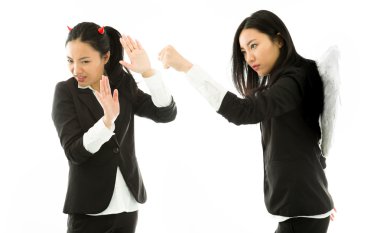 Angry white angel of a young Asian businesswoman punching the devil isolated on white background