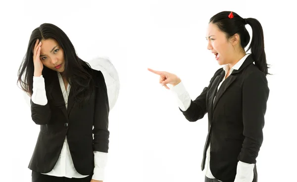 Diabo lado de uma jovem mulher de negócios asiática mostrando o dedo, gritando e repreendendo ao lado do anjo isolado no fundo branco — Fotografia de Stock