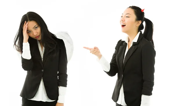 Diabo lado de uma jovem mulher de negócios asiática rindo no lado anjo isolado no fundo branco — Fotografia de Stock