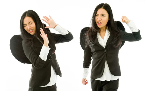 Dos jóvenes empresarias asiáticas vestidas de ángel negro peleando entre sí aisladas sobre fondo blanco —  Fotos de Stock