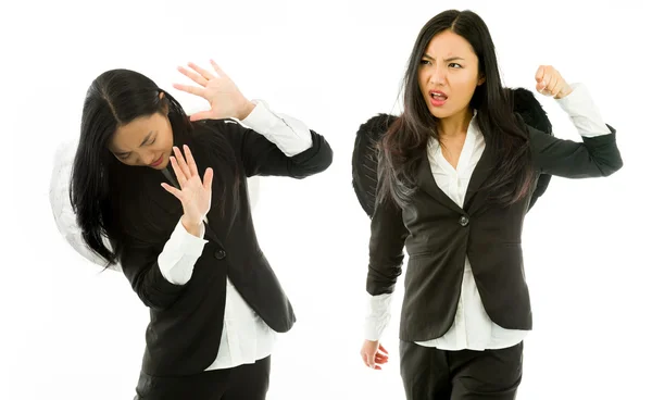 Asiatique jeune femme d'affaires habillée comme un ange noir frapper l'ange blanc isolé sur fond blanc — Photo