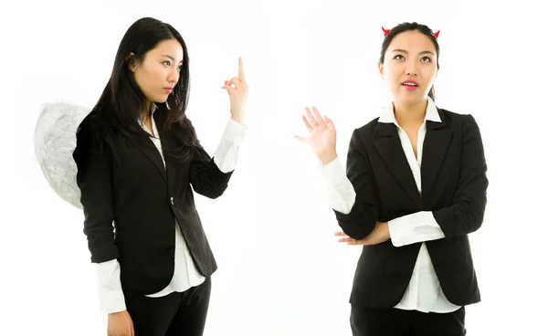 Ángel lado de una joven mujer de negocios asiática mostrando gesto obsceno al lado del diablo aislado sobre fondo blanco — Foto de Stock