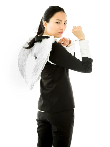 Angel side of a young Asian businesswoman with handcuffs and looking angry isolated on white background — Stockfoto