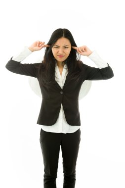 Irritated Asian young businesswoman dressed up as an angel putting fingers in ears