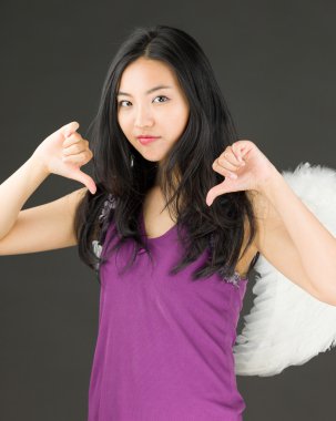 Başparmak aşağı her iki el işaretiyle gösterilen genç bir Asyalı kadın tarafında melek