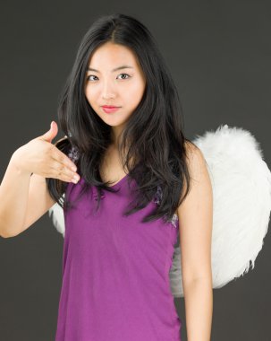 Melek yan el el sıkışma ve gülümseyen sunan genç bir Asyalı kadın