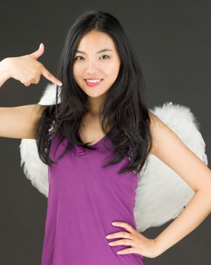 Kendini gösteren ve gülümseyen genç bir Asyalı kadın tarafında melek