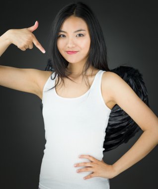 Bir melek gibi davranarak ve kendini gösteren Asyalı genç kadın giyinmiş