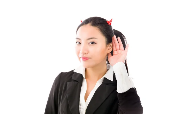 Devil side of a young Asian businesswoman trying to listen isolated on white background — Stock Photo, Image