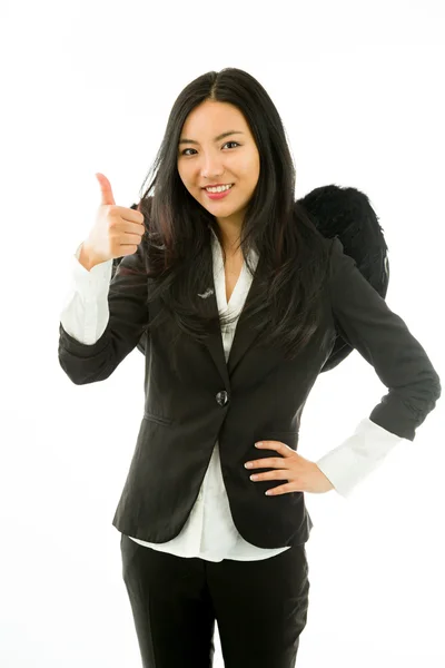 Asian young businesswoman dressed up as black angel making thumbs up sign standing with hand on hip — 图库照片