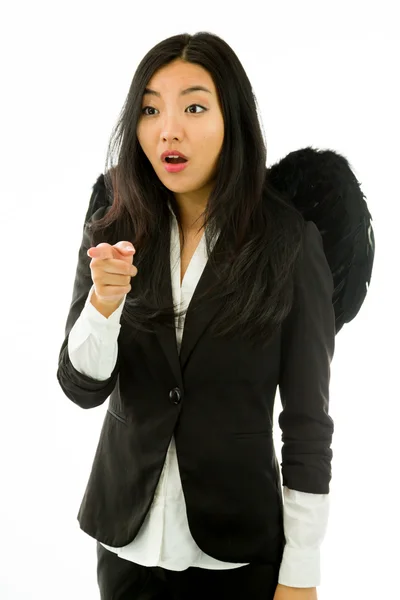 Shocked Asian young businesswoman dressed up as black angel pointing isolated on white background — Stock fotografie
