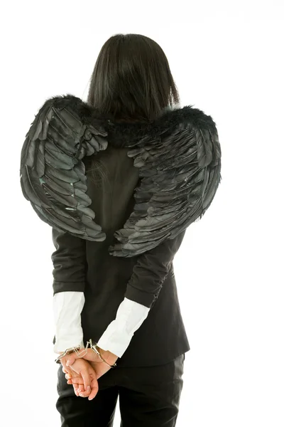 Rear view of a Asian young businesswoman dressed up as black angel handcuffs isolated on white background — Zdjęcie stockowe