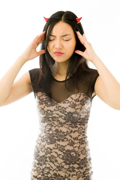 Asian young woman dressed up as a devil  and suffering from headache isolated on white background — Stock Photo, Image