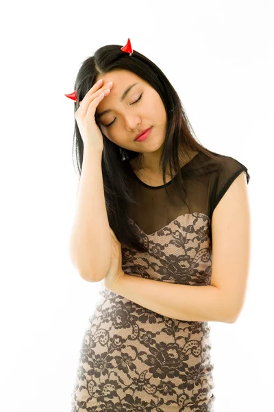 Upset Asian young woman dressed up as a devil with her head in hands isolated on white background — Stockfoto