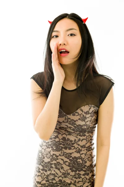 Asian young woman dressed up as a devil  and whispering isolated on white background — Φωτογραφία Αρχείου