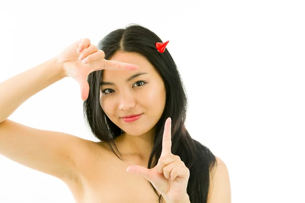 Devil side of a young naked Asian woman making frame with fingers and smiling — Stockfoto