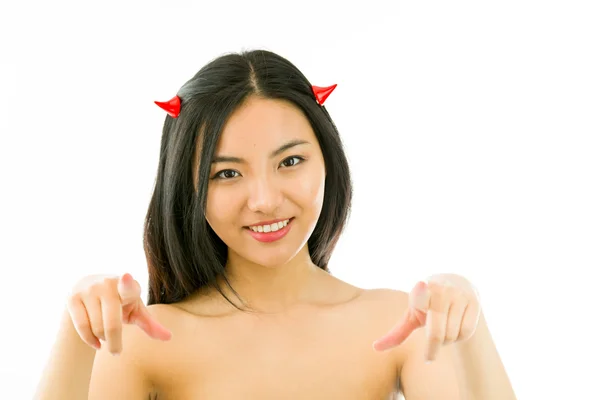 Côté diable d'une jeune femme asiatique nue pointant avec les deux mains et souriant — Photo