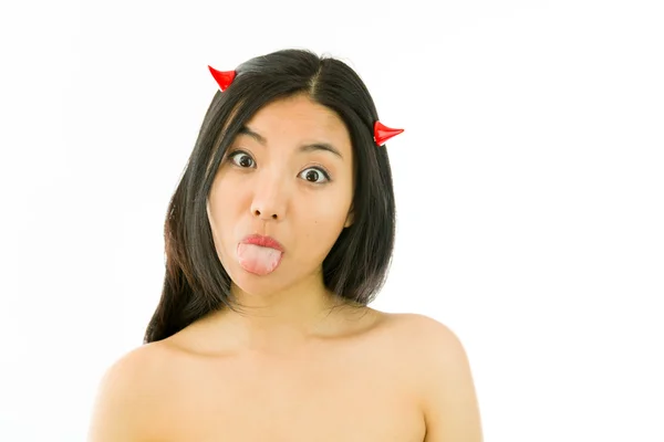 Devil side of a young naked Asian woman sticking out her tongue — Stockfoto