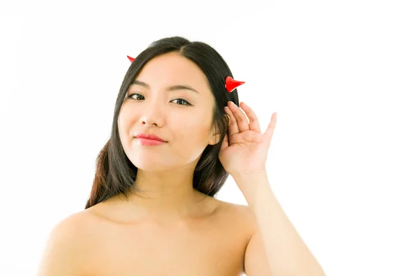 Devil side of a young naked Asian woman trying to listen — Stockfoto